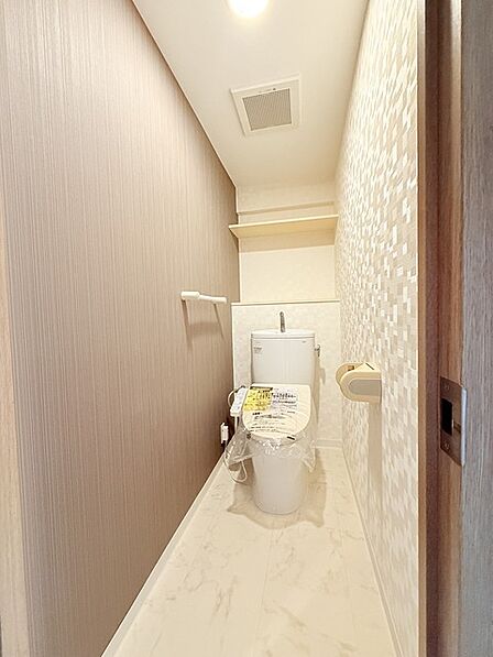 ウォシュレット機能付きのトイレ。収納もあり実用性も兼ね備えた造り。 