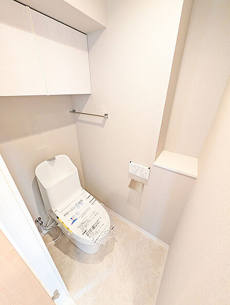 ウォシュレット機能付きのトイレ。収納もあり実用性も兼ね備えた造り。
