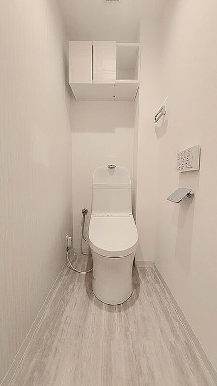 ウォシュレット機能付きのトイレ。収納もあり実用性も兼ね備えた造り。