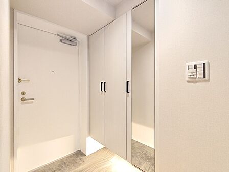 大きな靴棚を配した玄関ホール。靴棚に設置した姿見鏡はお出かけ前の身だしなみチェックにお役立てください！