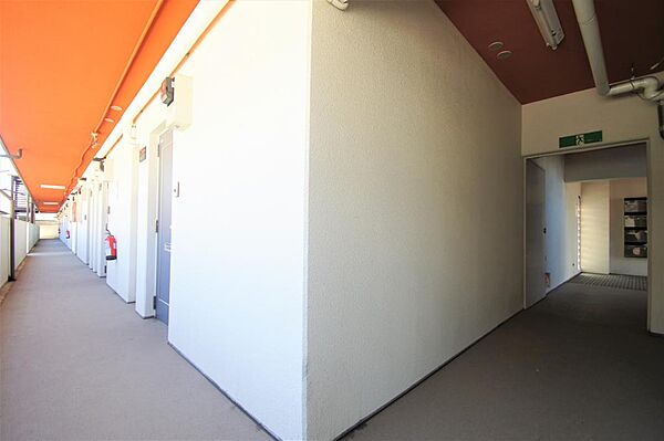 画像25:共用廊下、明るいオレンジ色の天井が特徴的です。