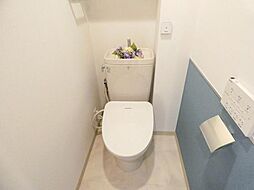 [トイレ] 【トイレ】ブルーのアクセントクロスが施されたトイレは、温水洗浄便座付き。吊戸棚付きで、お掃除用品などをスッキリと収納◎