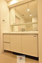 [洗面] 大きく見やすい三面鏡で清潔感ある洗面台は、身だしなみチェックや肌のお手入れに最適です。何かと荷物が増える場所だからこそ、スッキリと見映えの良い空間に拵えました。