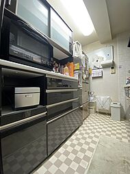 [キッチン] キッチンの後ろには収納棚があるため、たっぷりのお皿やお鍋もすっきりと。引き出して使える炊飯器コーナーもあるので、便利にお使いいただけます。